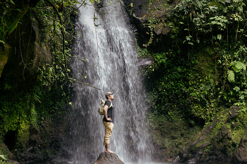 Man standing in front of a waterfall